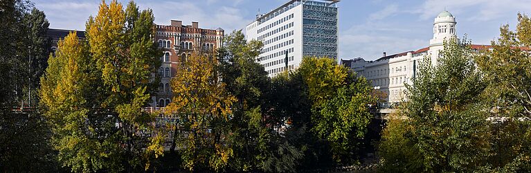 Foto von Gebäude am Oskar-Morgenstern-Platz. Außenperskpektive vom Donaukanal mit Bäumen © Gebhard Sengmüller